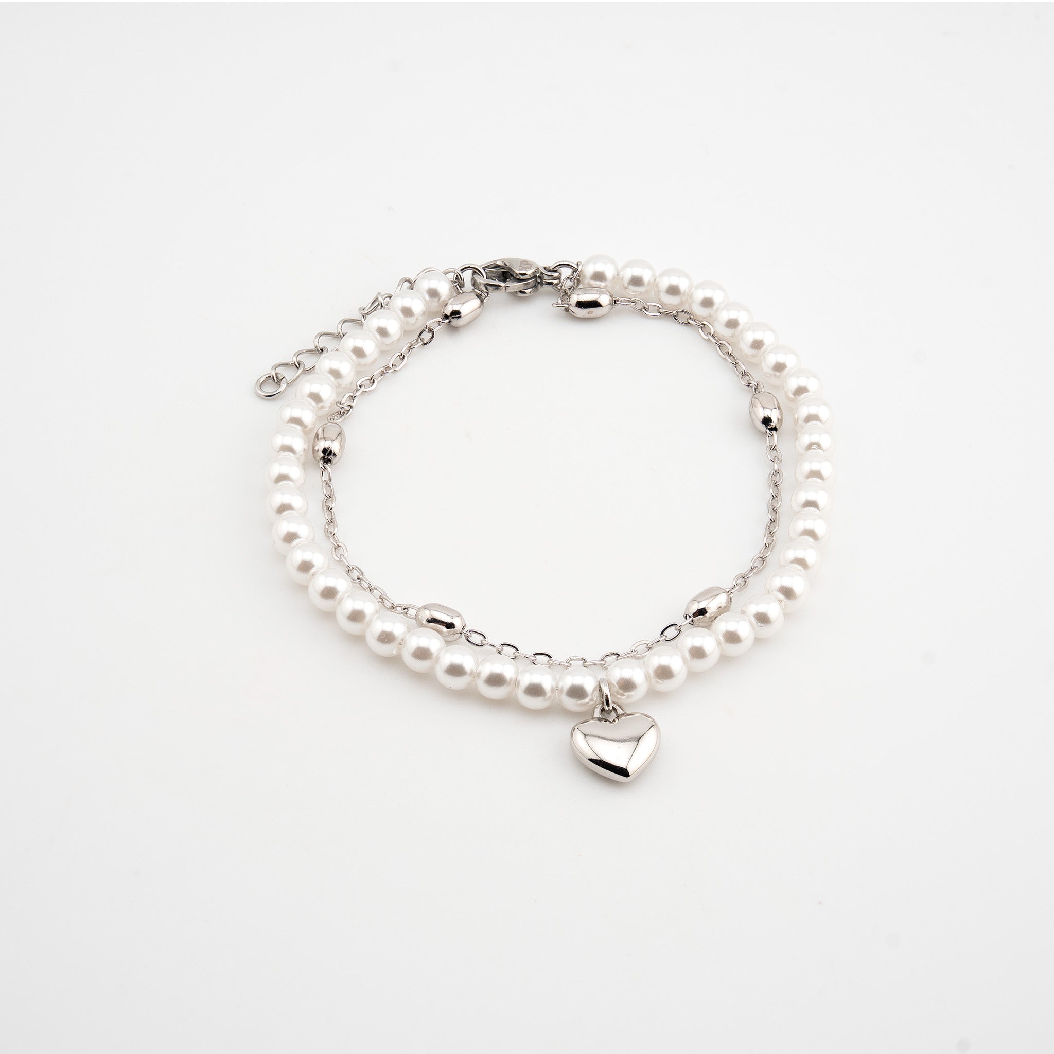 Pulsera plateada con perlas sintéticas y dije de corazón
