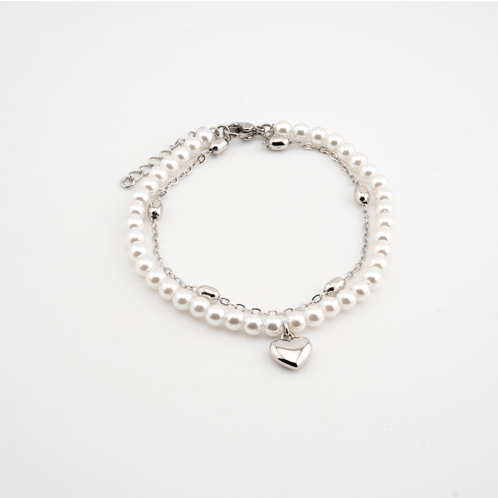 Pulsera plateada con perlas sintéticas y dije de corazón