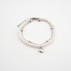 Pulsera plateada con perlas sintéticas y dije de corazón