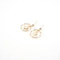 Aretes dorados con sol y luna al centro rodeados de zirconias.