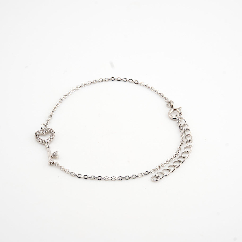 Pulsera plateada con dije de llave con cristales
