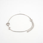 Pulsera plateada con dije de llave con cristales