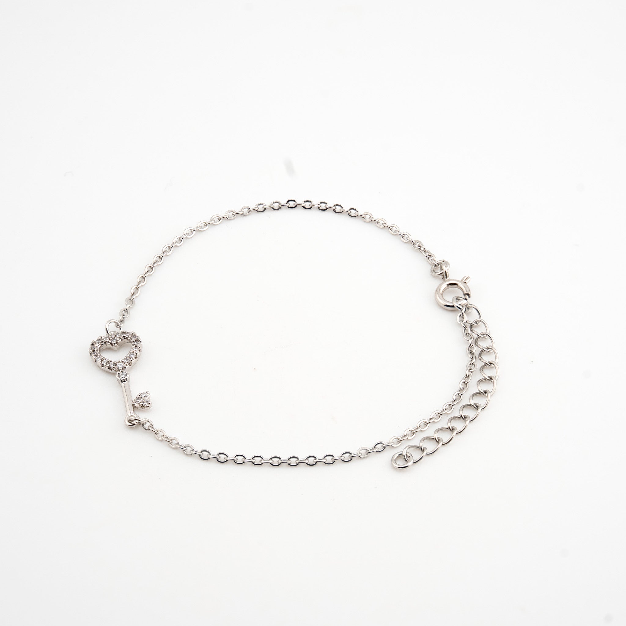 Pulsera plateada con dije de llave con cristales
