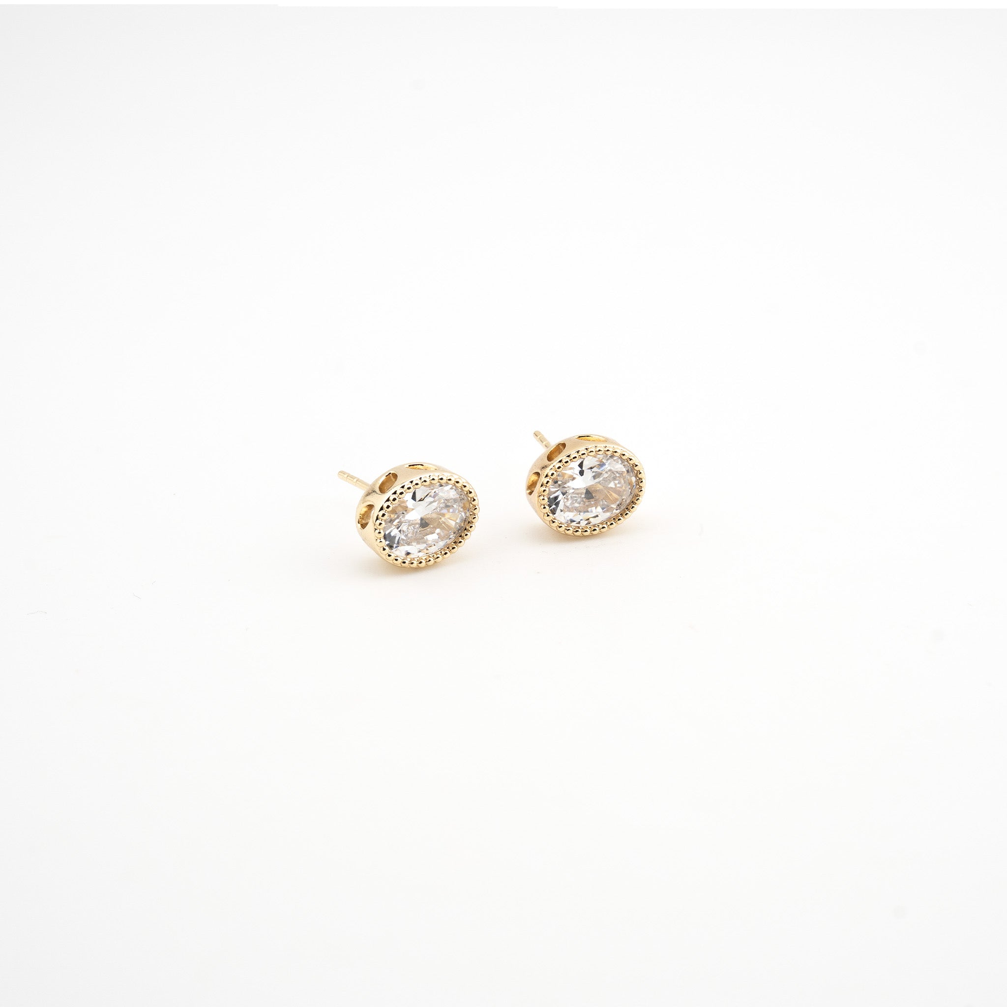 Aretes dorados en forma ovalada con una zirconia al centro