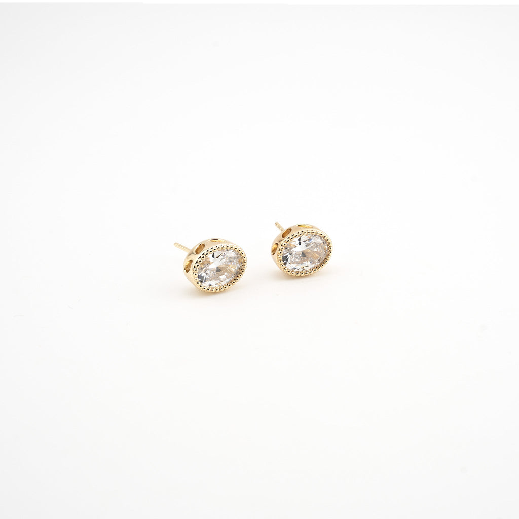 Aretes dorados en forma ovalada con una zirconia al centro